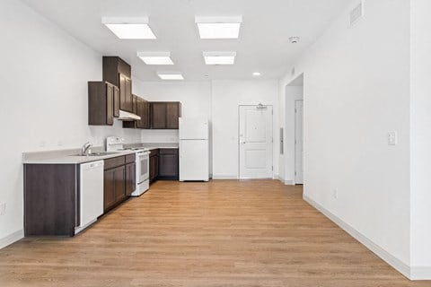 a kitchen with white walls and a wooden floor